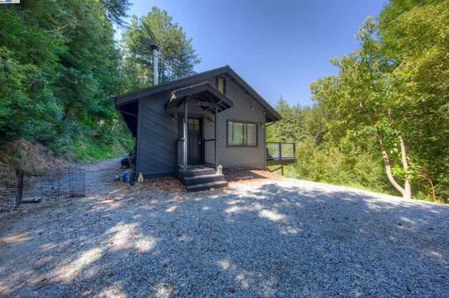 a view of a house with a yard and large tree