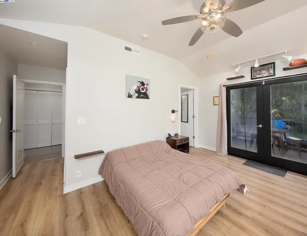 a spacious bedroom with a bed and a chandelier