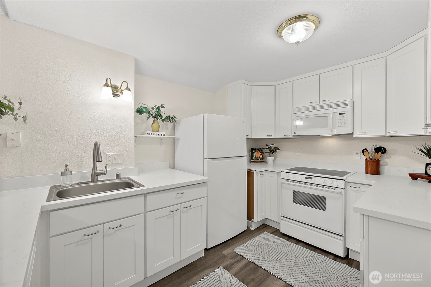 1117 17th Street Southwest Puyallup, WA 98371 - Photo 14 of 40 a kitchen with a sink dishwasher a stove and white cabinets