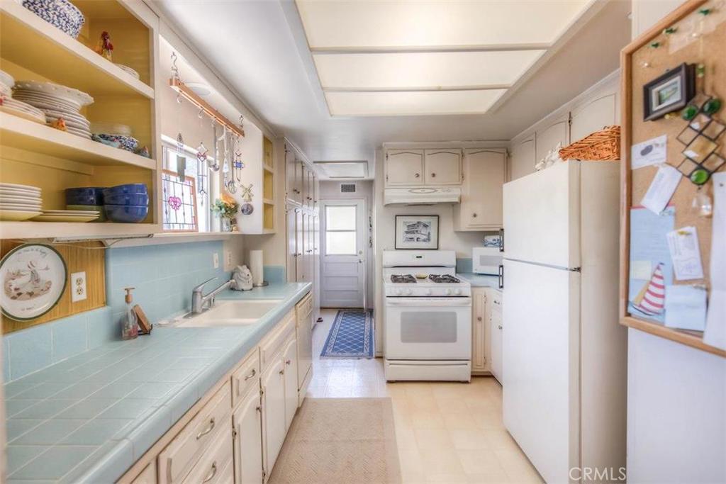 612 South Orange Street Orange, CA 92866 - Photo 18 of 44 a kitchen with stainless steel appliances a refrigerator a sink and white cabinets