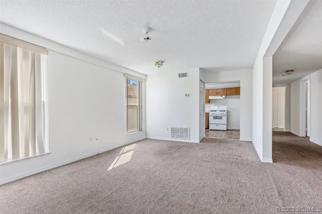 an empty room with closet and windows