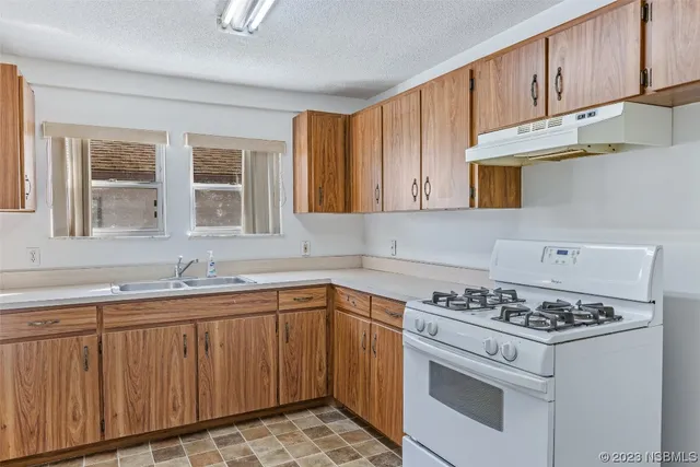 a kitchen with stainless steel appliances granite countertop a sink stove oven a sink and dishwasher with cabinets