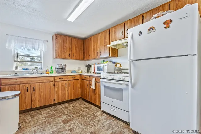 a white refrigerator freezer sitting inside of a kitchen