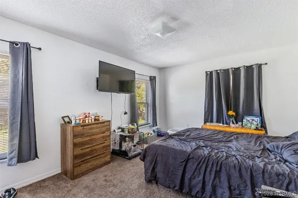 a bedroom with a bed and a flat tv screen on wall
