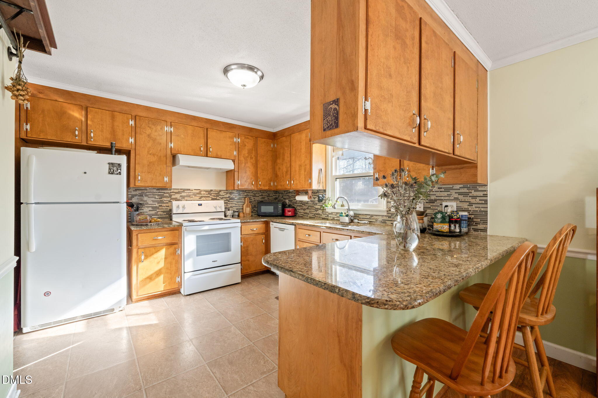 2802 Glover Road Durham, NC 27703 - Photo 12 of 44 a kitchen with stainless steel appliances granite countertop a stove a refrigerator a oven a sink with a dining table and chairs