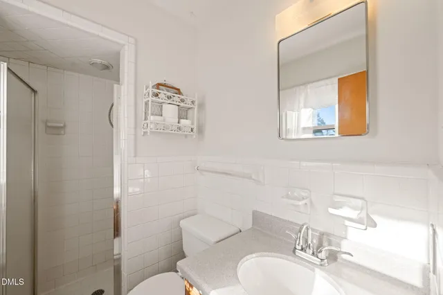 a bathroom with a toilet sink vanity and mirror