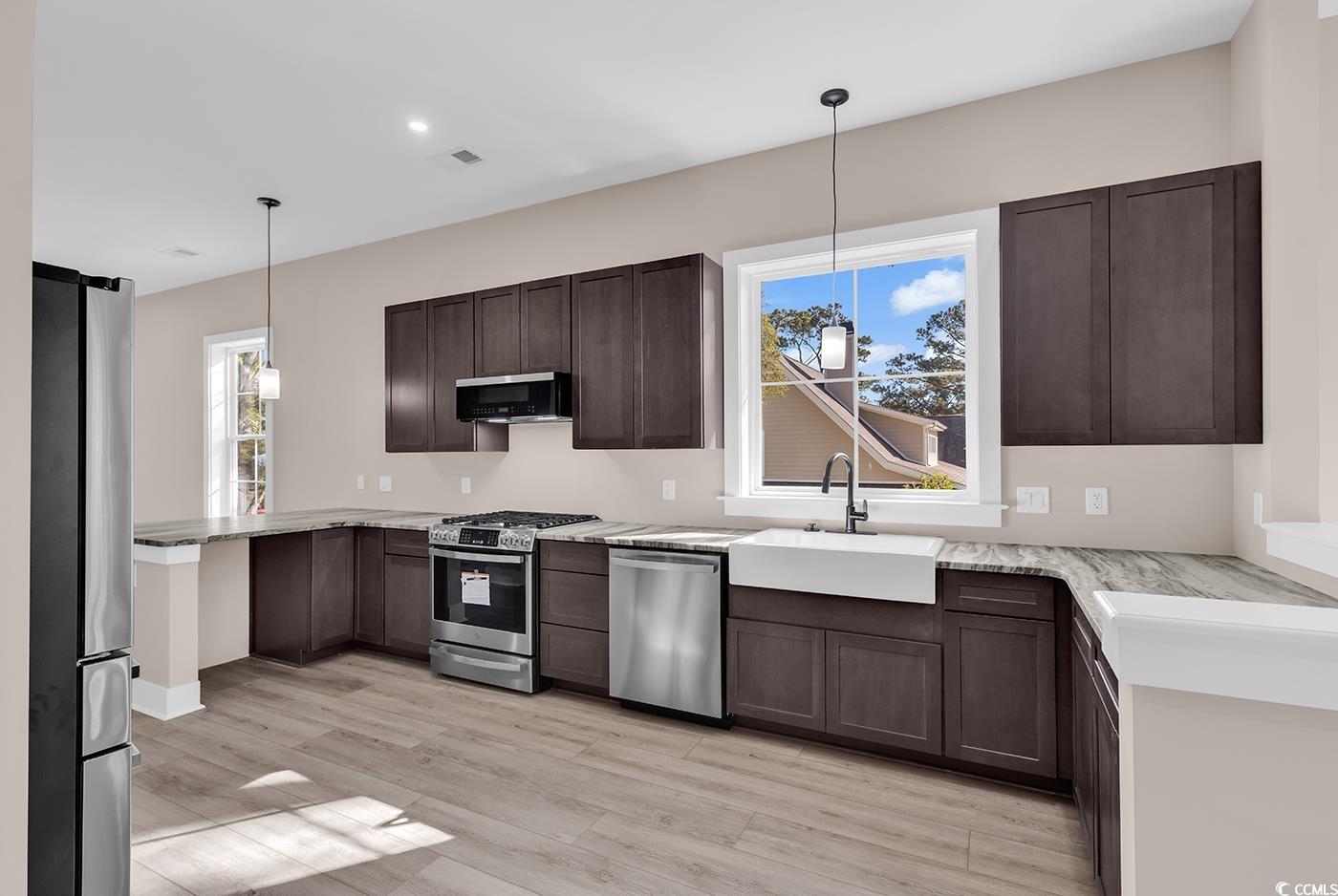 535 Mary Lou Avenue Murrells Inlet, SC 29576 - Photo 9 of 30 Kitchen featuring a peninsula, stainless steel appliances, dark brown cabinets, pendant lighting, and recessed lighting