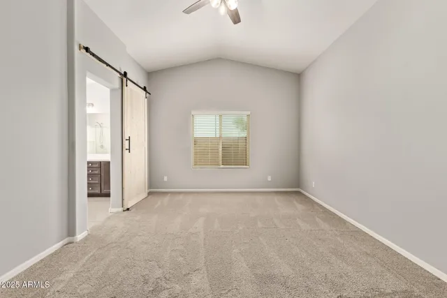an empty room with a window and a ceiling fan