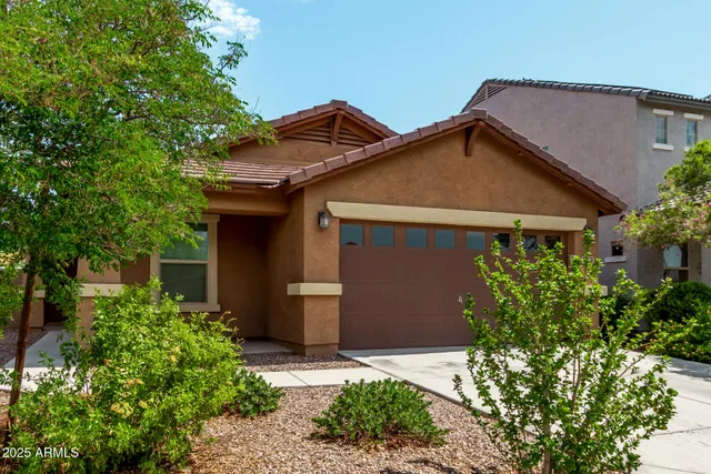 a front view of a house with a yard and trees