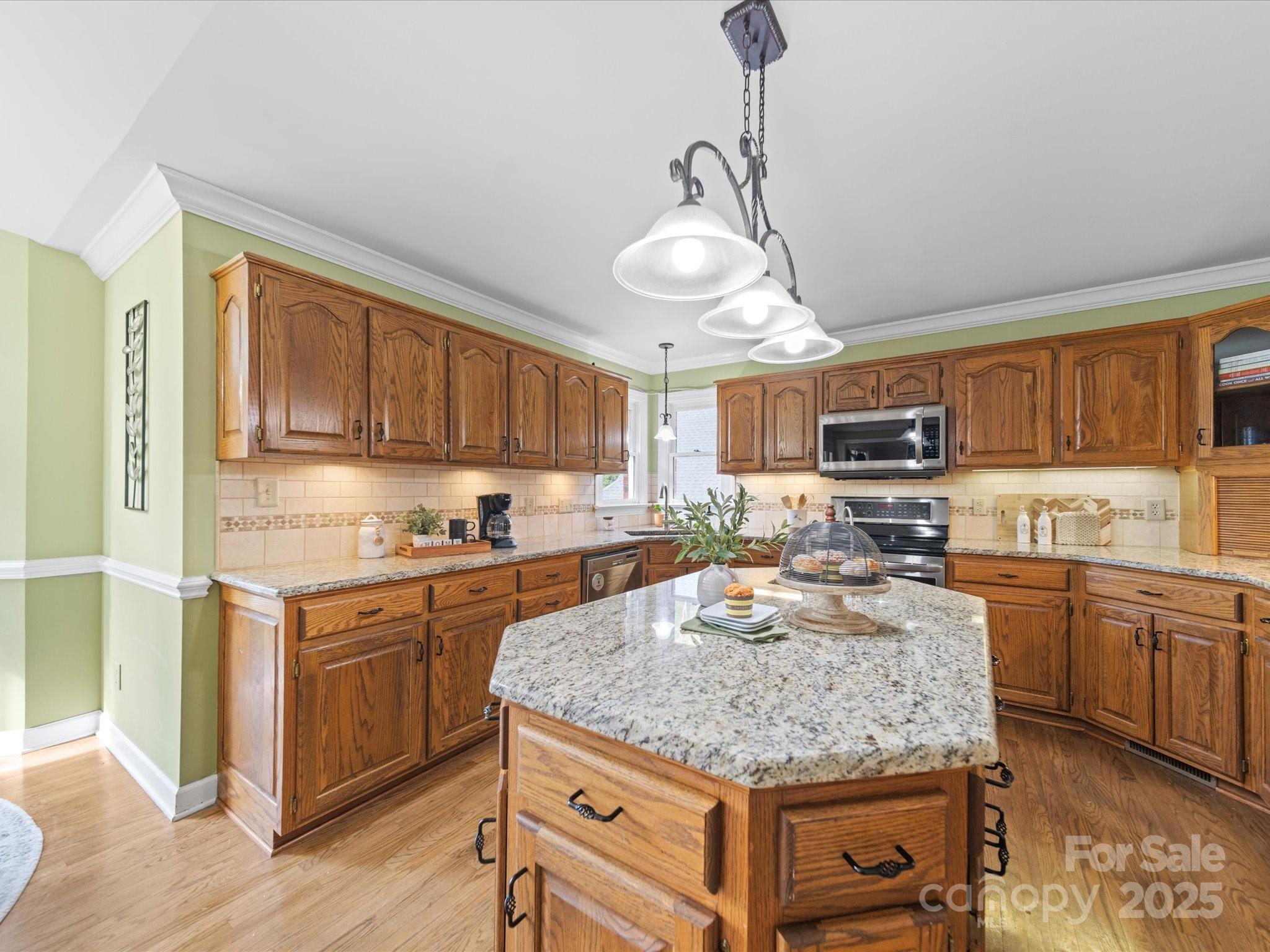 106 Berea Baptist Church Road Stanfield, NC 28163 - Photo 13 of 48 a kitchen with stainless steel appliances granite countertop a stove top oven a sink dishwasher a dining table and chairs with wooden floor