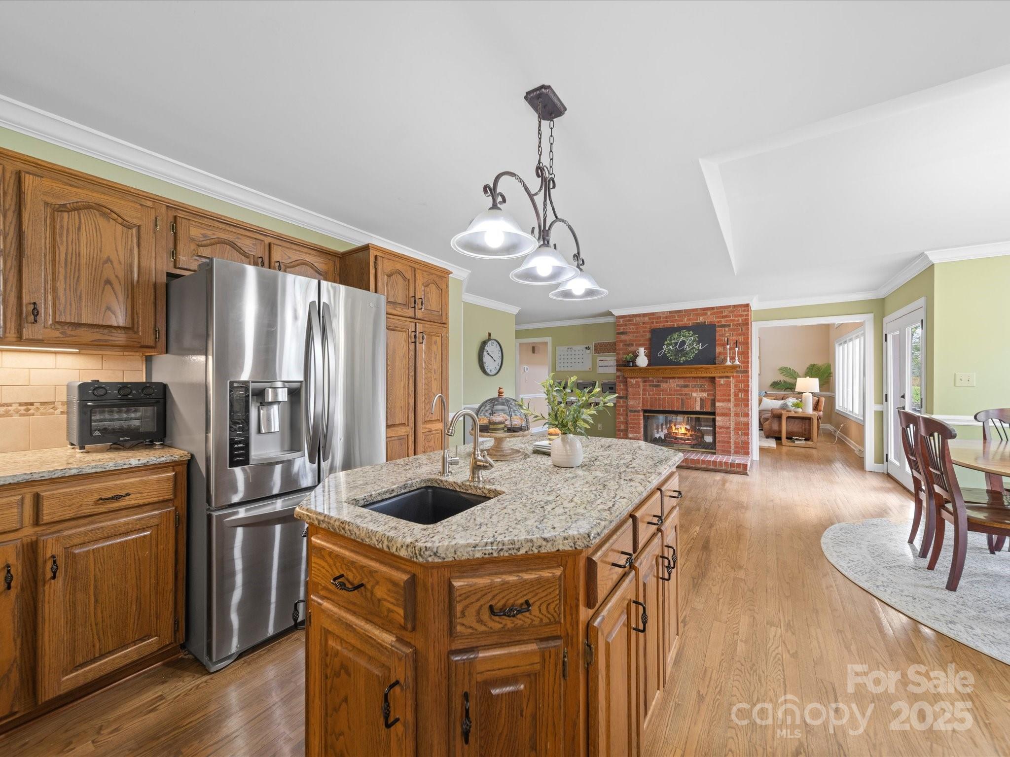 106 Berea Baptist Church Road Stanfield, NC 28163 - Photo 17 of 48 a kitchen with a refrigerator a stove a sink dishwasher a dining table and chairs with wooden floor