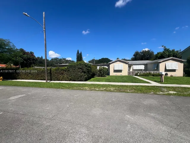a view of a house with a big yard and a large tree