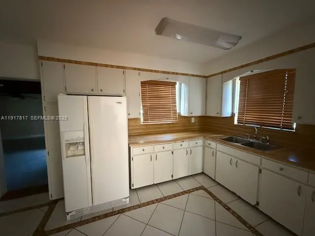 a kitchen with granite countertop cabinets and refrigerator