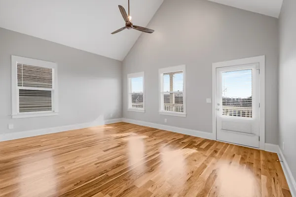 a view of a livingroom with wooden floor and a ceiling fan