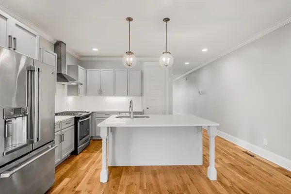 a kitchen with kitchen island a sink stainless steel appliances and cabinets