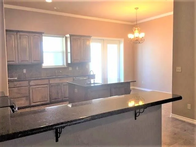 a kitchen with a sink and chandelier