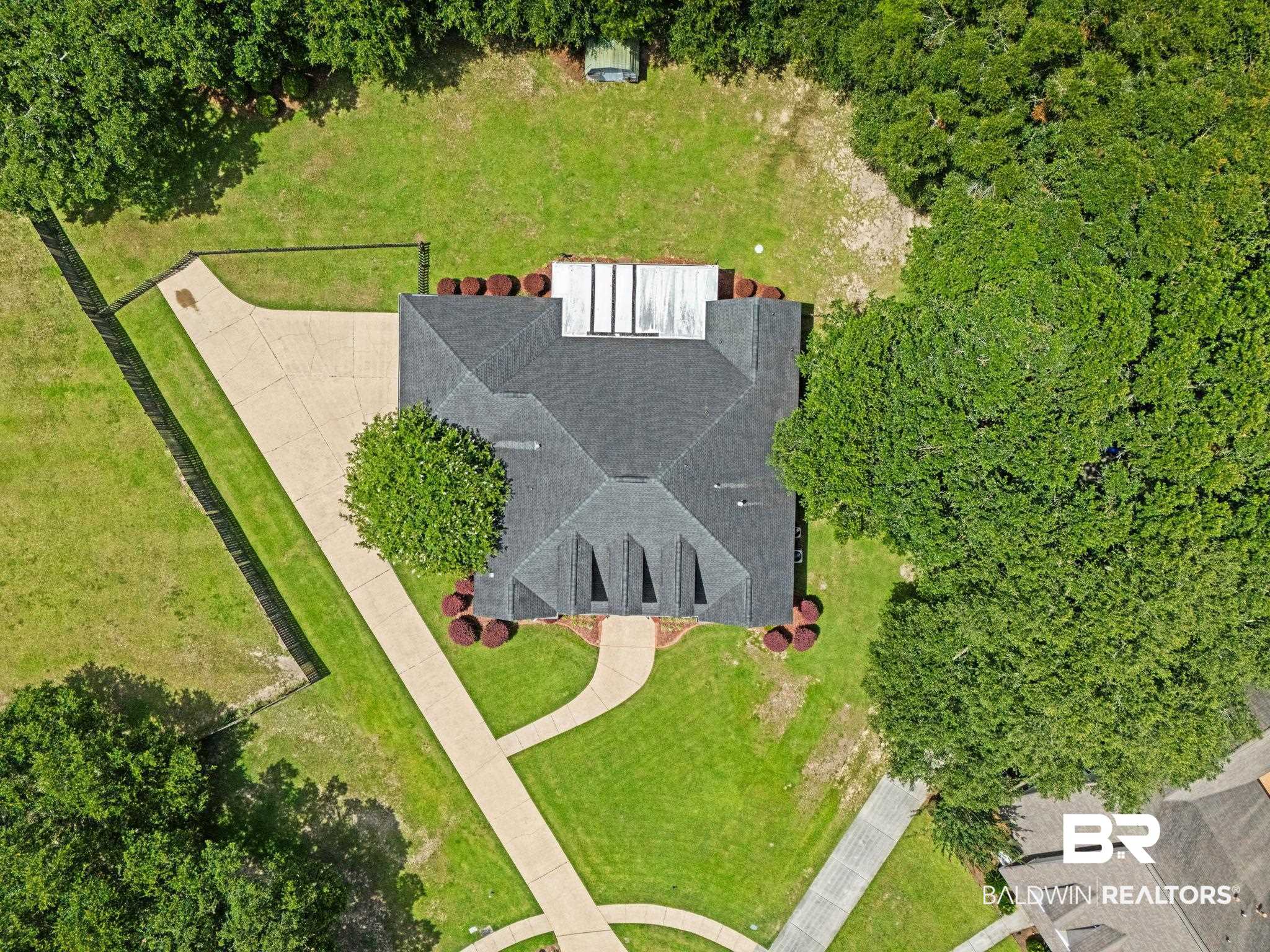 3176 Cedar Court Mobile, AL 36619 - Photo 32 of 33 Gabled roofline residence featuring a concrete driveway, manicured lawn, established perimeter trees, and landscaping with mature shrubs