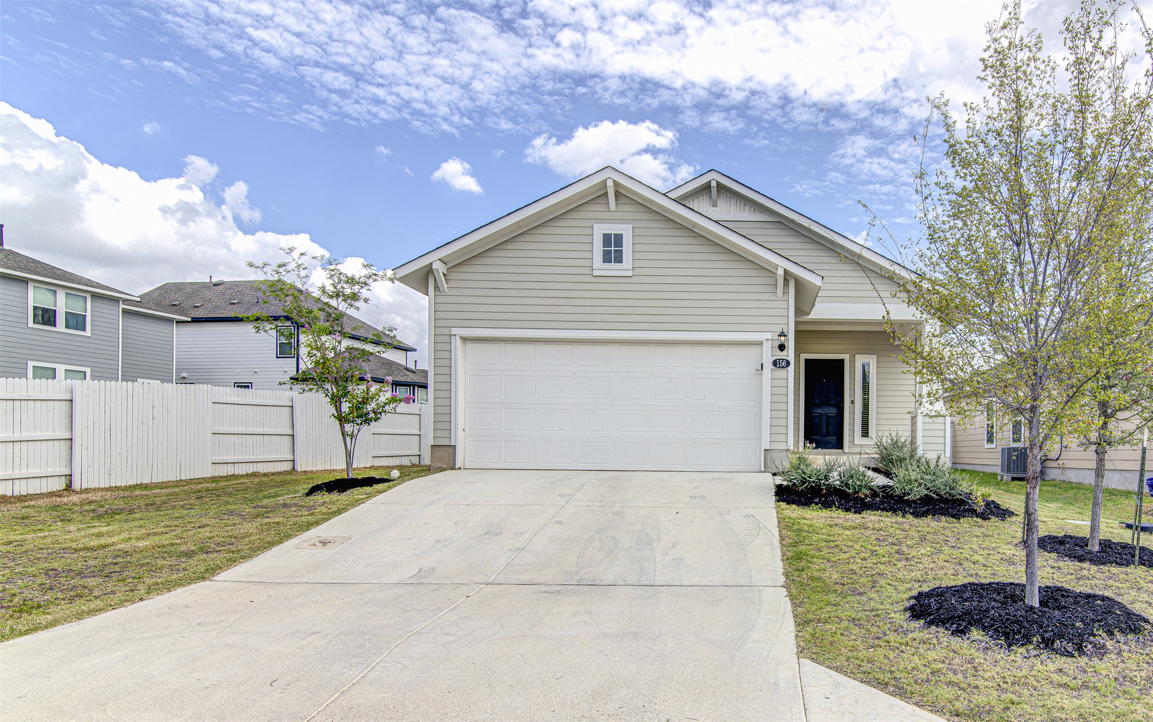 156 Tillage Road Elgin, TX 78621 - Photo 1 of 25 A welcoming front exterior showcasing a neatly paved driveway leading to an integrated garage.