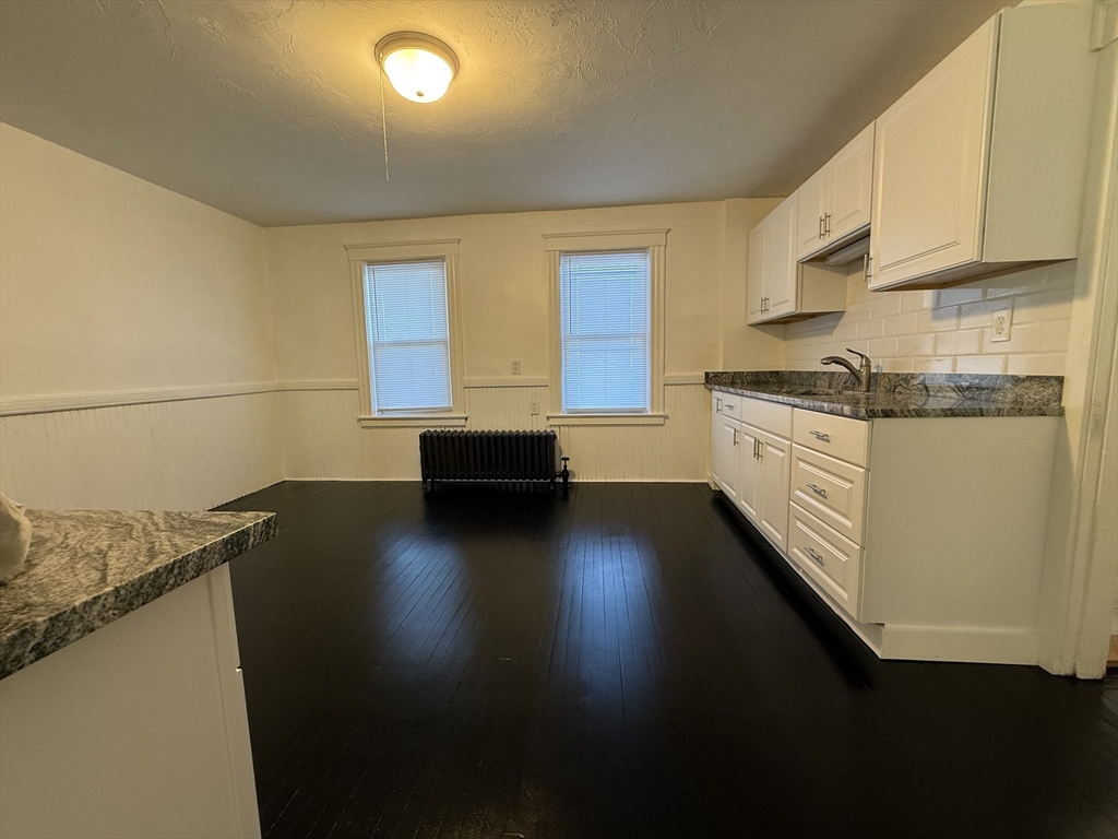 18-38 Beaver Court Framingham, MA 01702 - Photo 2 of 10 a kitchen with granite countertop a stove a sink dishwasher and a microwave oven on the blue kitchen countertops
