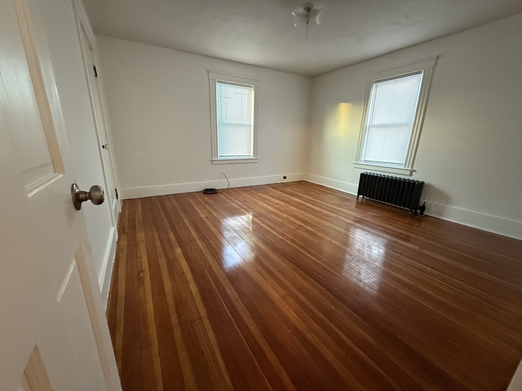 18-38 Beaver Court Framingham, MA 01702 - Photo 3 of 10 an empty room with wooden floor and windows