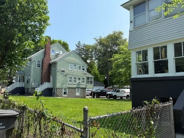 a front view of a house with a yard and potted plants