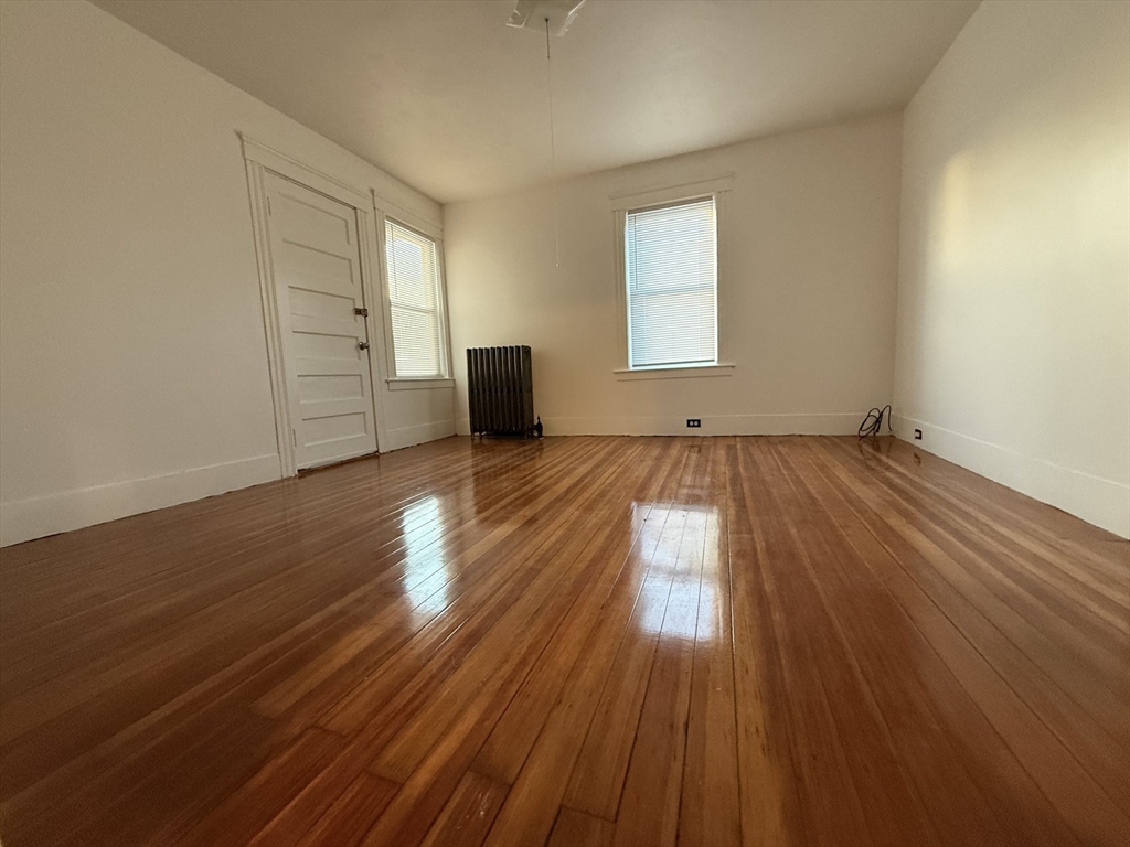 18-38 Beaver Court Framingham, MA 01702 - Photo 4 of 10 an empty room with wooden floor and windows