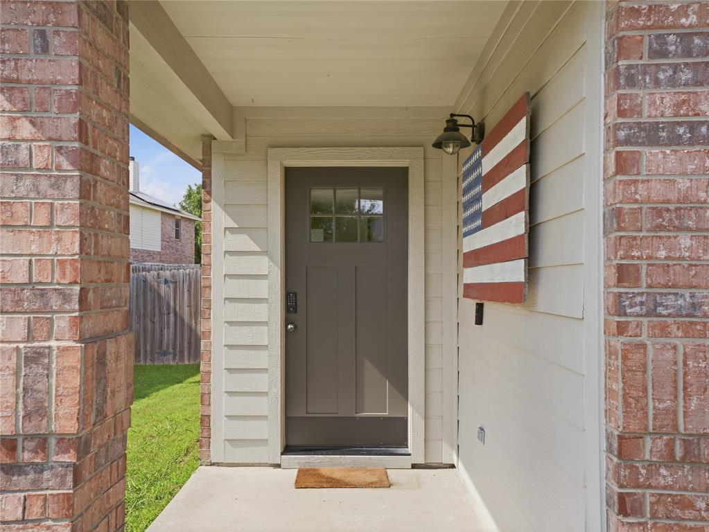 12724 Carpenter Lane Rhome, TX 76078 - Photo 7 of 37 Inviting front entry featuring a gray paneled door with glass inserts, a smart lock, and an overhead porch light fixture