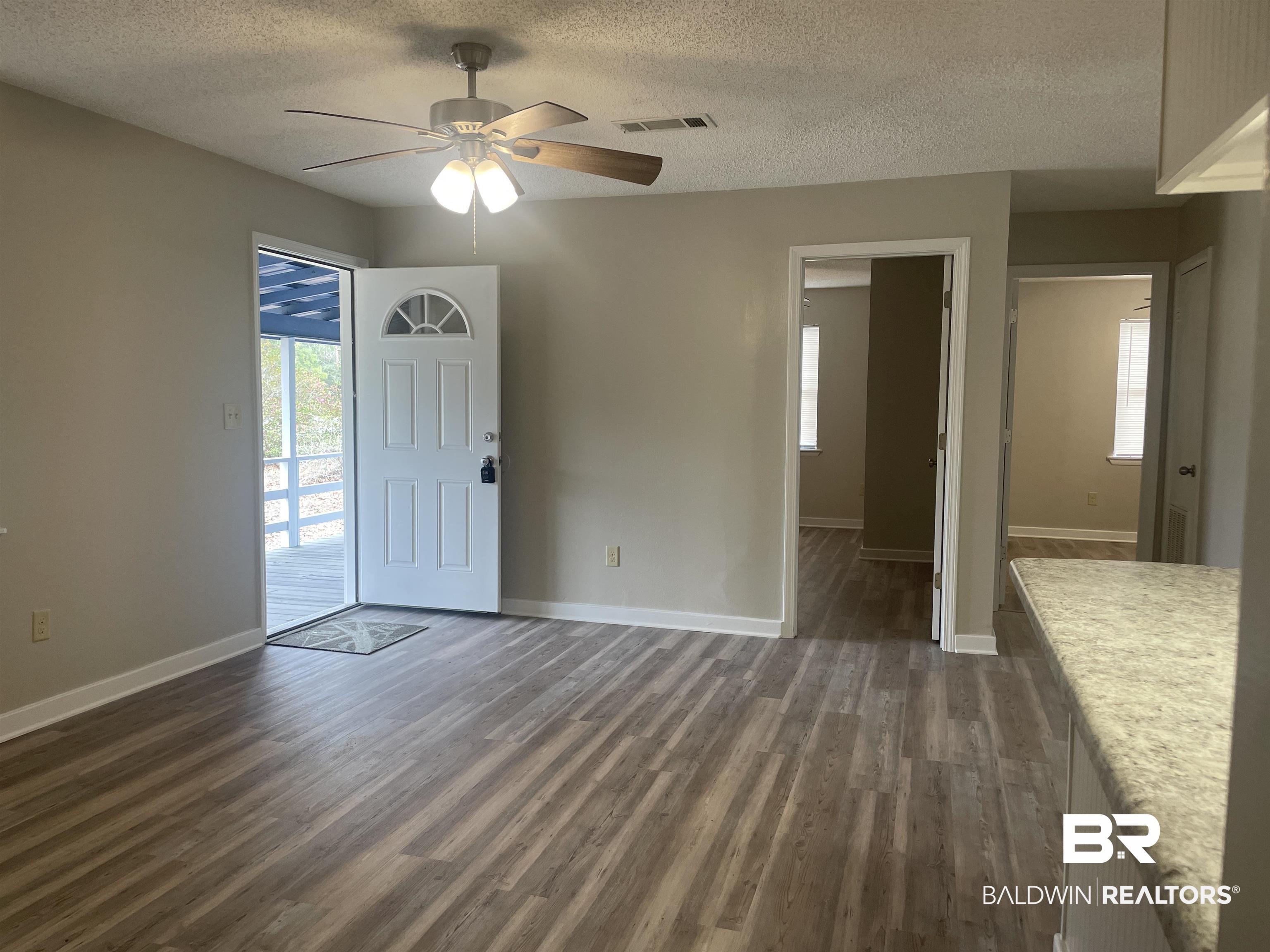 28414 Highway 31 Flomaton, AL 36441 - Photo 2 of 11 Entryway with dark wood finished floors, visible vents, baseboards, and ceiling fan