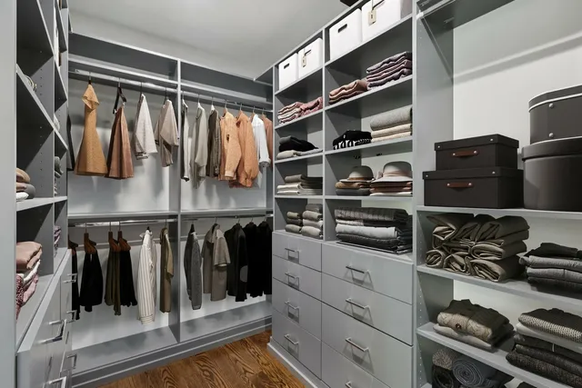 a view of walk in closet with clothes and shoes