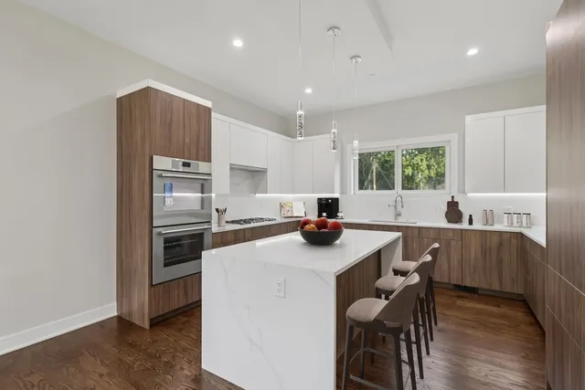 a kitchen with a sink a stove a refrigerator a dining table and chairs