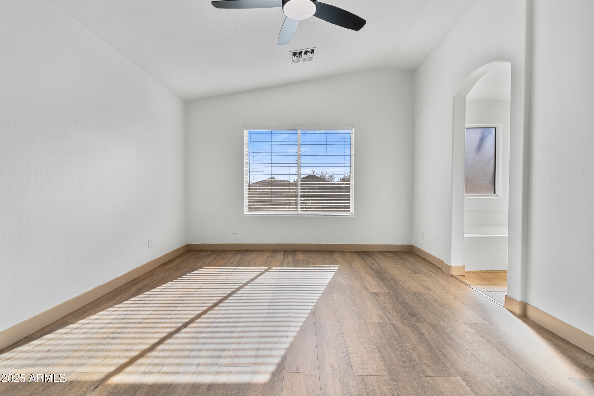 16329 West Rimrock Street Surprise, AZ 85388 - Photo 17 of 31 a view of an empty room with a window and wooden floor