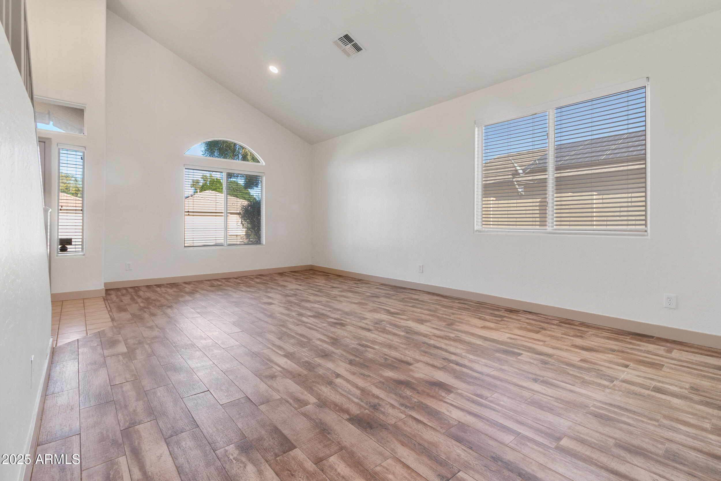 16329 West Rimrock Street Surprise, AZ 85388 - Photo 5 of 31 an empty room with wooden floor and windows