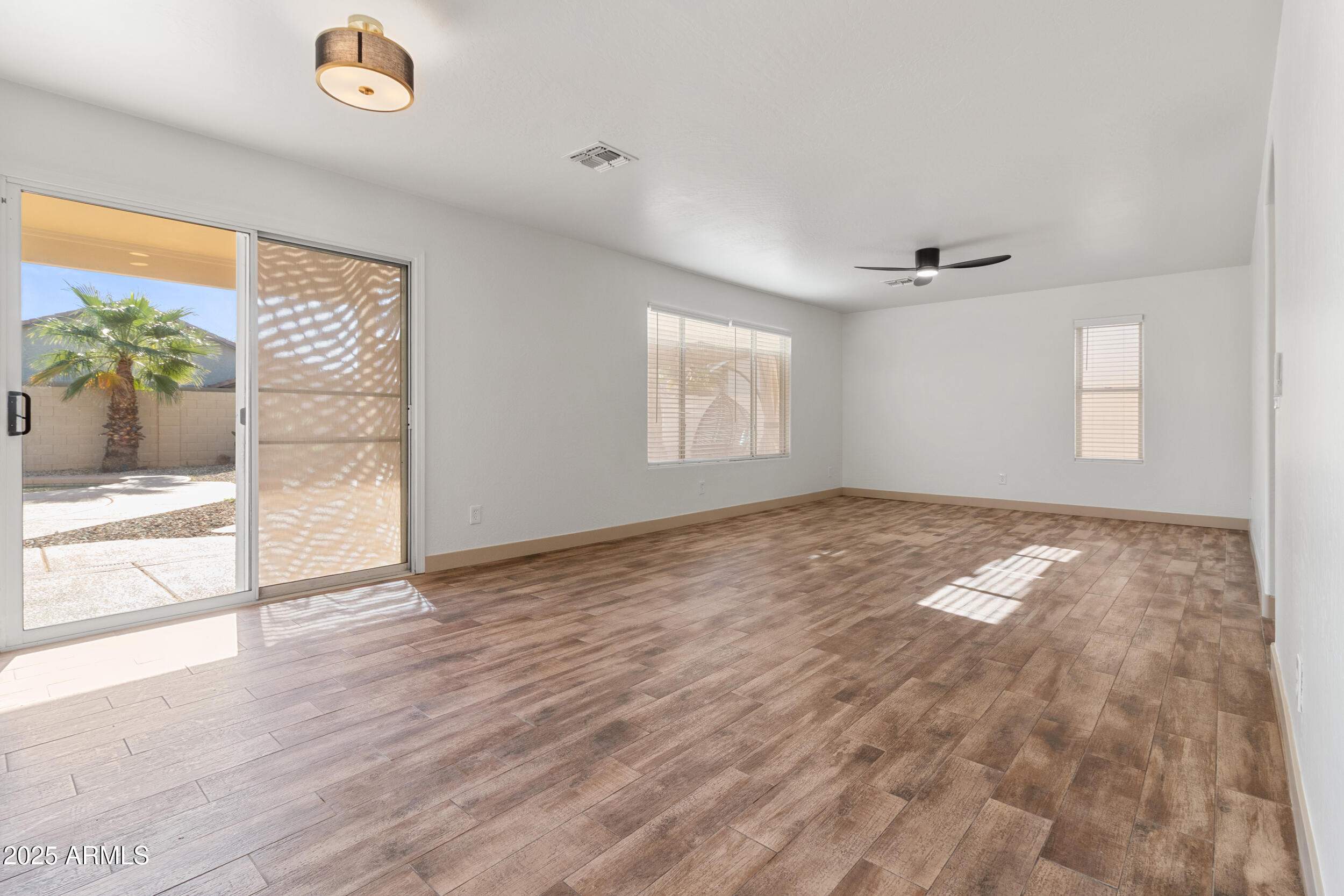 16329 West Rimrock Street Surprise, AZ 85388 - Photo 6 of 31 an empty room with wooden floor and windows
