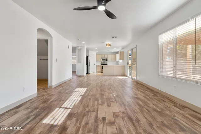 a view of empty room with wooden floor and window