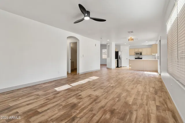 a view of an empty room and kitchen view