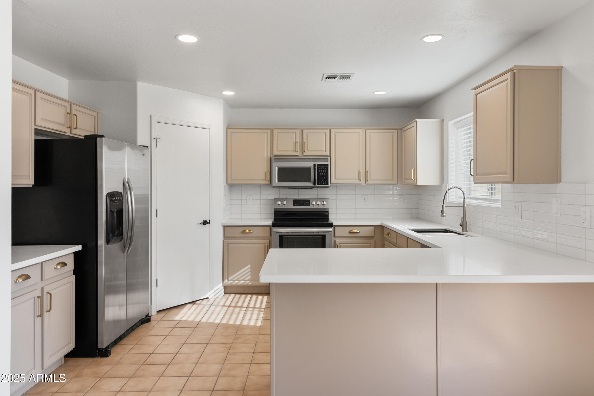 16329 West Rimrock Street Surprise, AZ 85388 - Photo 10 of 31 a kitchen with granite countertop a refrigerator and a sink