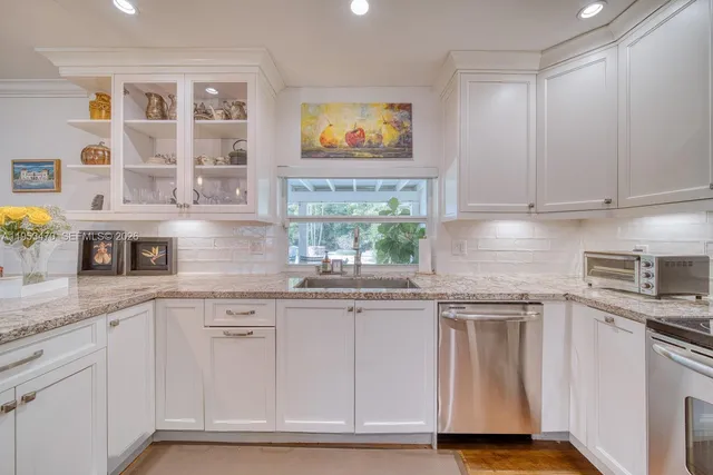 a kitchen with stainless steel appliances granite countertop a sink and cabinets