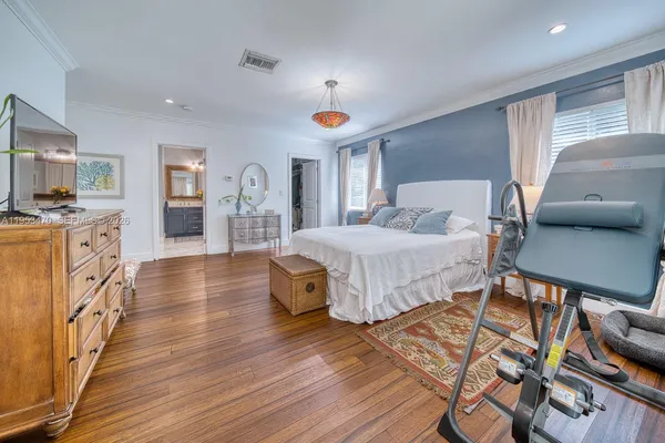 a bedroom with furniture and a wooden floor