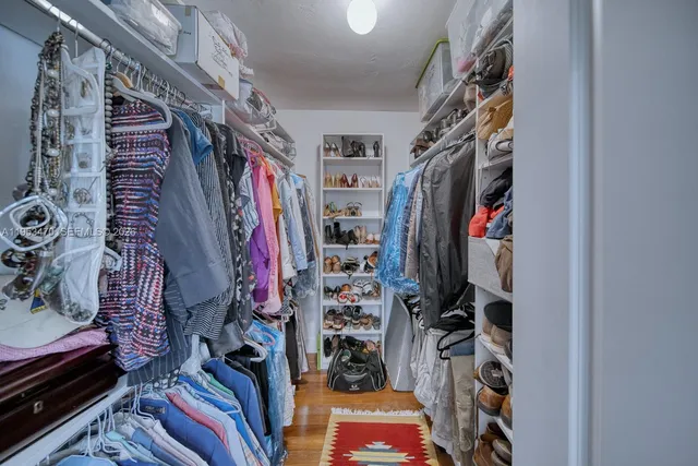 a view of walk in closet with clothes and shoes