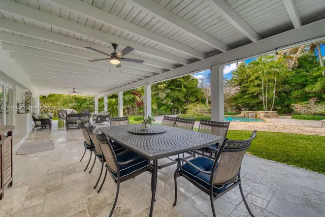 a view of a patio with a table chairs and a backyard