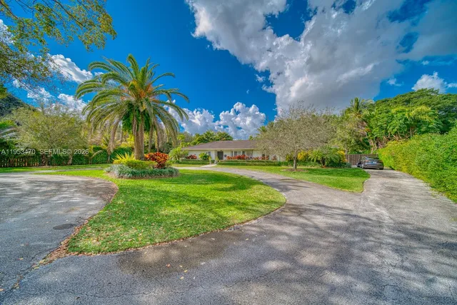 an aerial view of a house with a yard and lake view