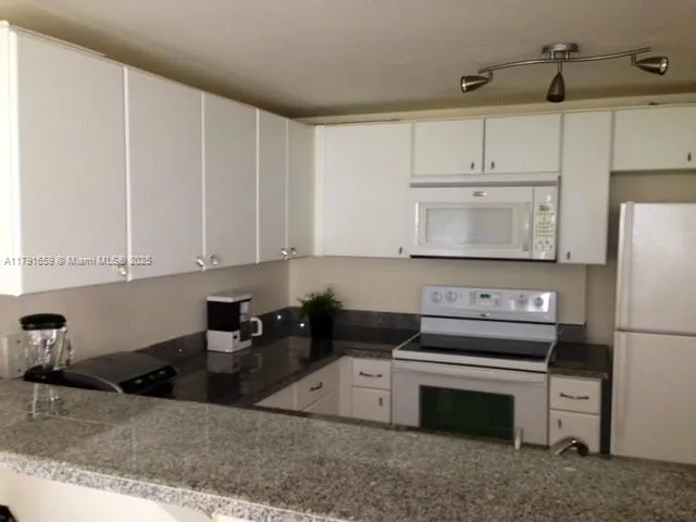a kitchen with a stove a refrigerator and cabinets