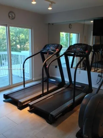 a room with gym equipment with a large window