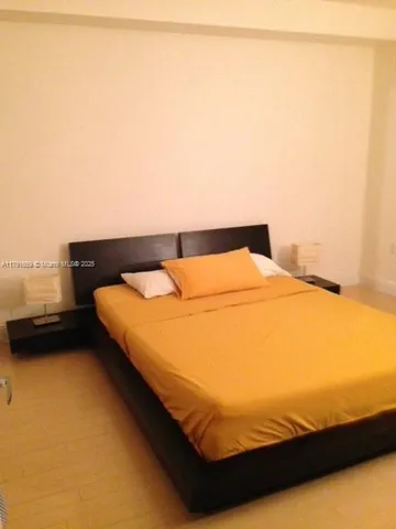 a bedroom with a bed and a night stand