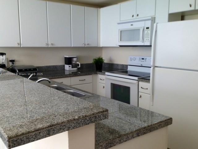 2740 Southwest 28th Terrace, Unit 304 Miami, FL 33133 - Photo 8 of 13 a kitchen with a sink stove and cabinets