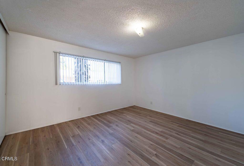 1925 Ginger Street, Unit 104 Oxnard, CA 93036 - Photo 10 of 25 an empty room with wooden floor and windows