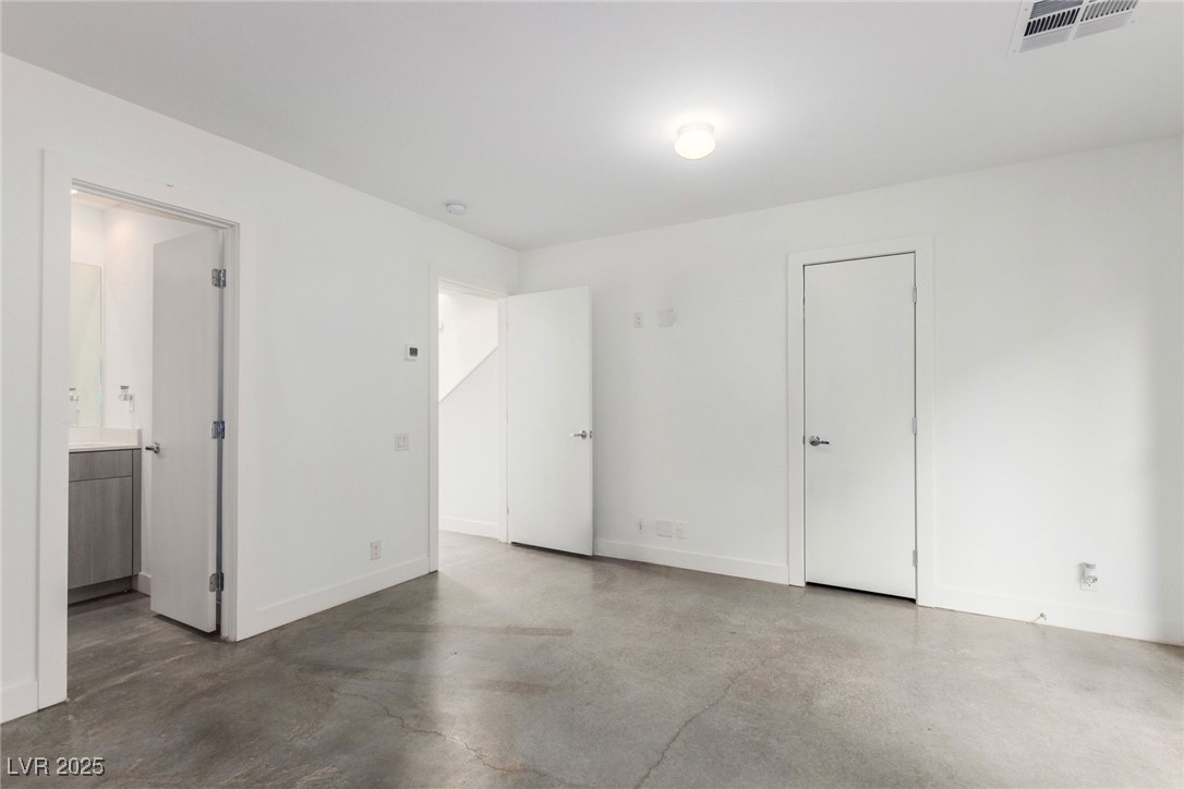 1998 Lewis Avenue Las Vegas, NV 89101 - Photo 7 of 48 Downstairs comfort meets urban flair in this bedroom with concrete floors and a personal bathroom—perfect for visitors or extended stays!