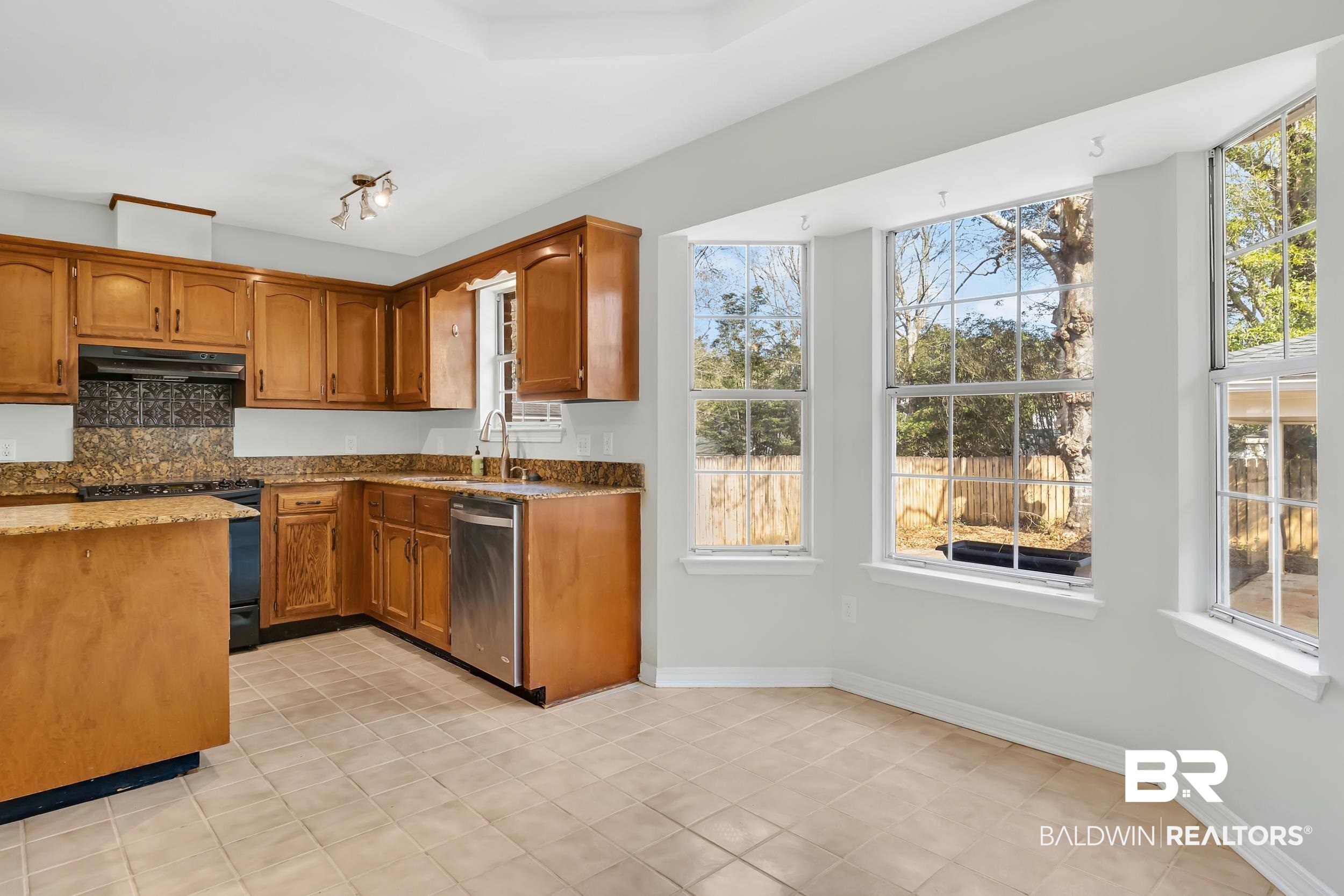 6616 Conde Court Mobile, AL 36695 - Photo 13 of 27 Kitchen with black electric range oven, under cabinet range hood, a sink, stone counters, and dishwasher