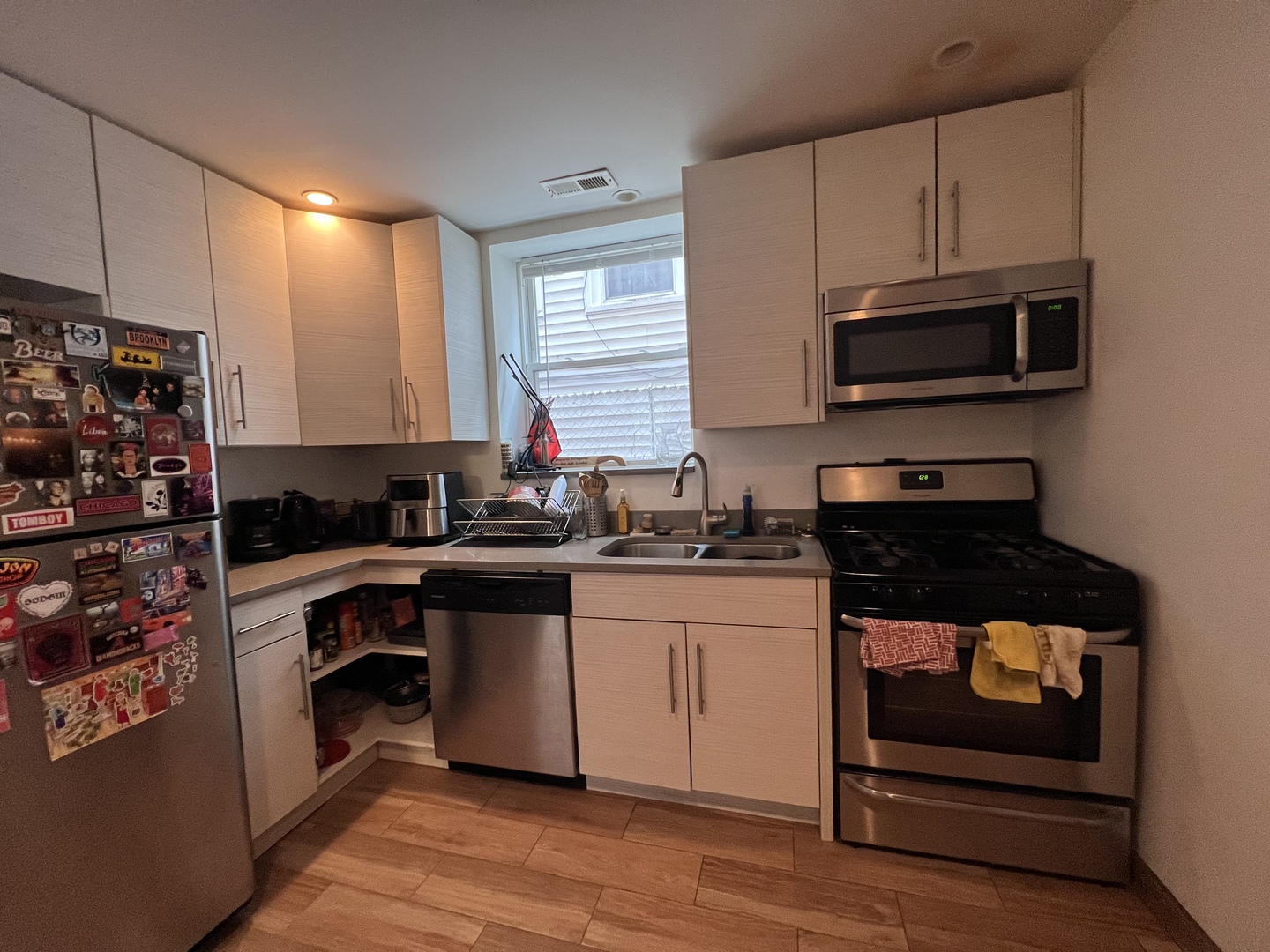 Undisclosed Address Chicago, IL 60618 - Photo 4 of 13 a kitchen with stainless steel appliances granite countertop a stove a sink and a microwave