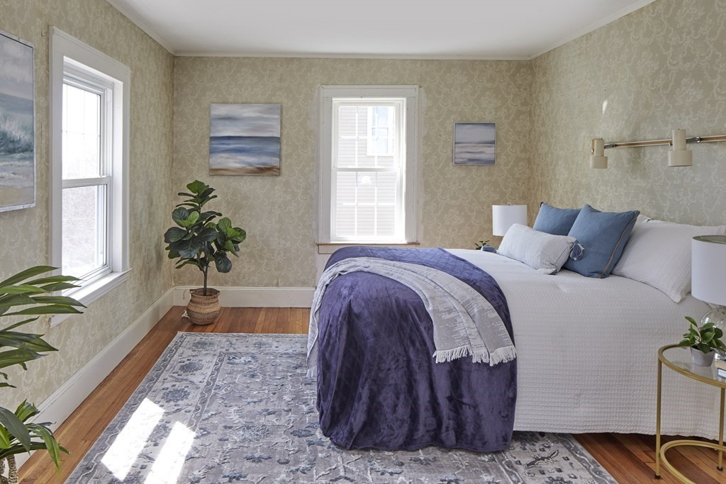 77 Standish Road Watertown, MA 02472 - Photo 8 of 16 a bedroom with a large bed and a potted plant